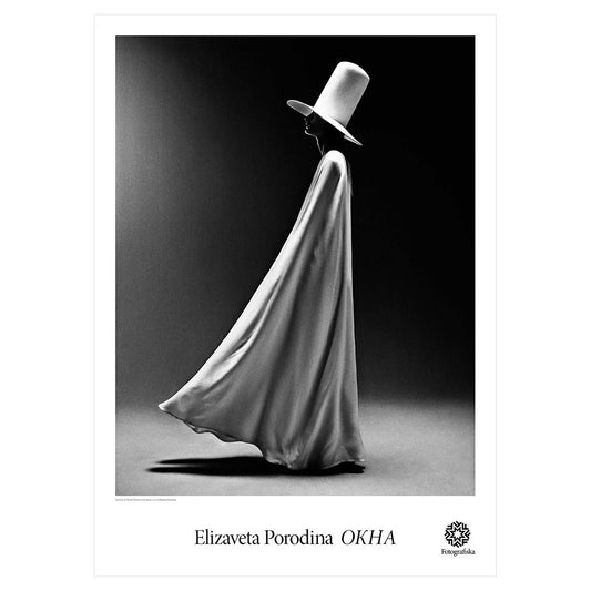 Black & white portrait of woman in long white cape and white hat on black background. Noir feel.  Exhibition title below: Elizaveta Porodina | OKHA
