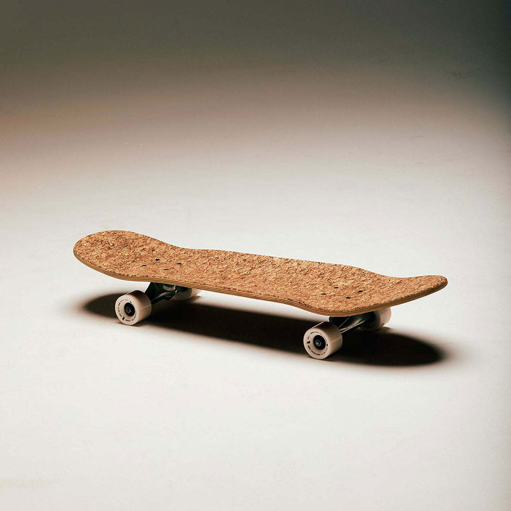 Cork and walnut skateboard laying on its wheels