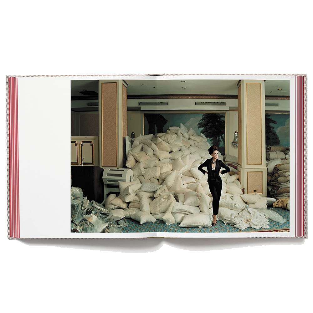 Open book shot of Wonderland, showing full-width color image of woman standing triumphantly beside a stag of bags