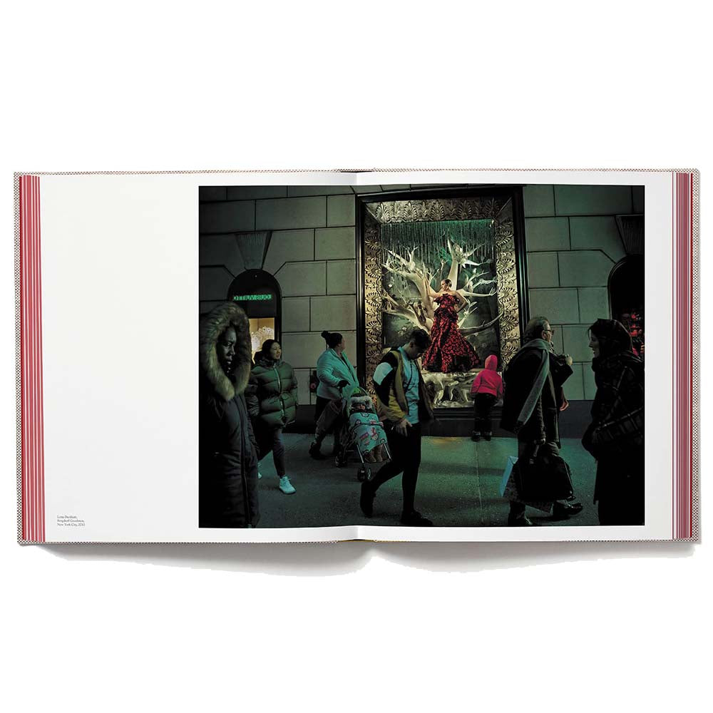 Open book shot of Wonderland, showing full-width color image of crowd walking by window