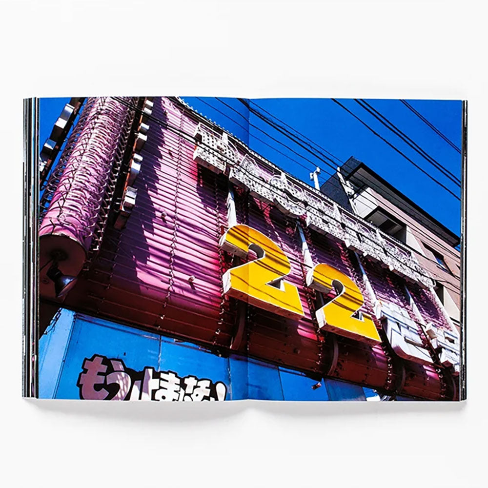 Spread of Daido Moriyama: How I Take Photographs, showing a colorful full-width building photo