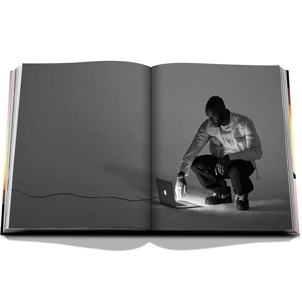 Spread of Louis Vuitton: Virgil Abloh, The Ultimate Collection, showing full-width black and white image of a fashion model on a laptop.  Very sparse