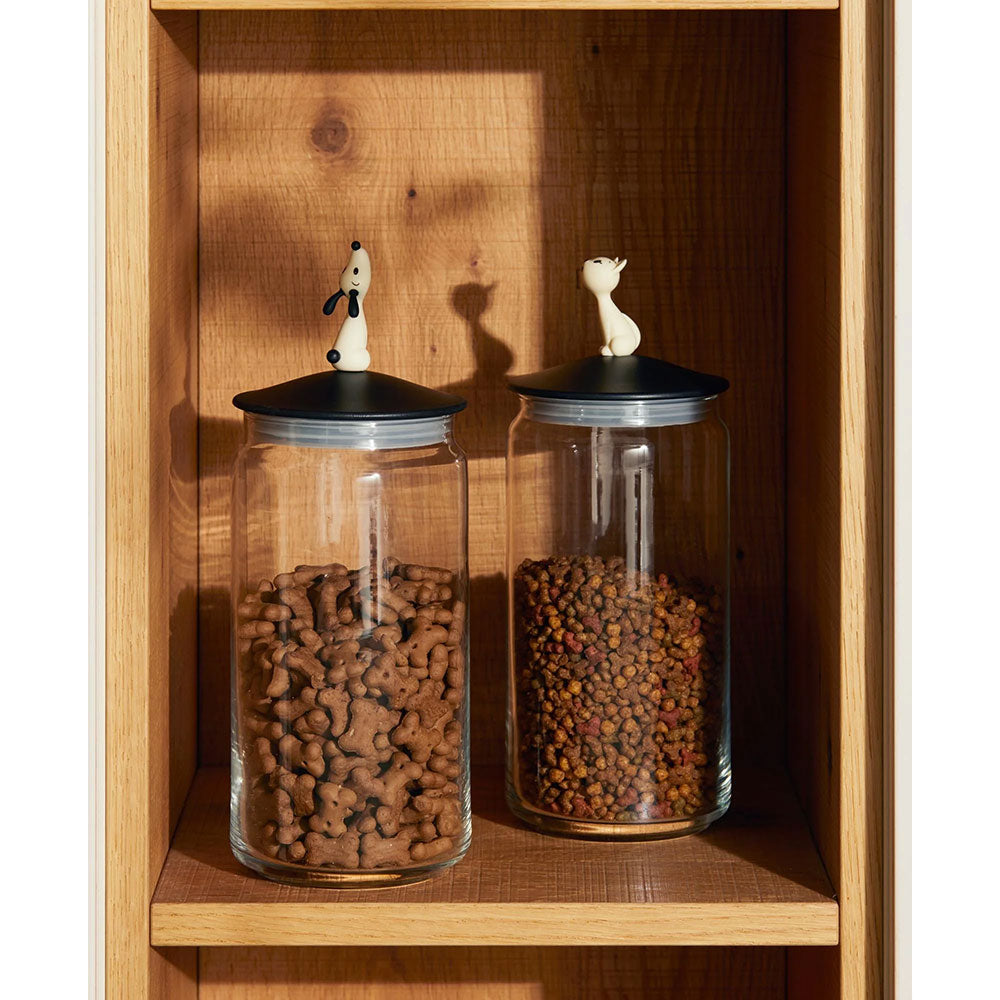 Miò Jar, Black - tall glass jar with mini sculpture of cat as lid holder, sitting on a wood shelf filled with cat food.