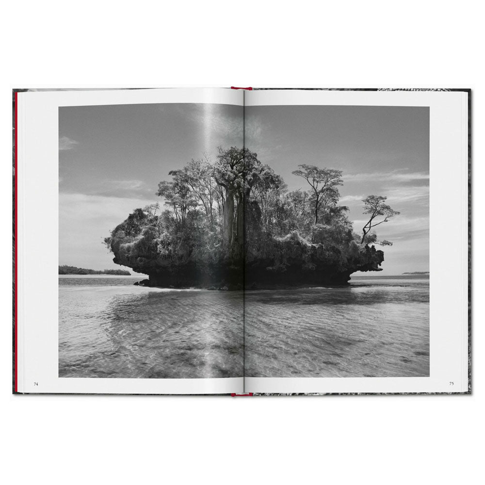 Spread shot of Genesis by Sebastiao Salgado, showing a black and white full-width photo of a grass landscape in the miiddle of the ocean.