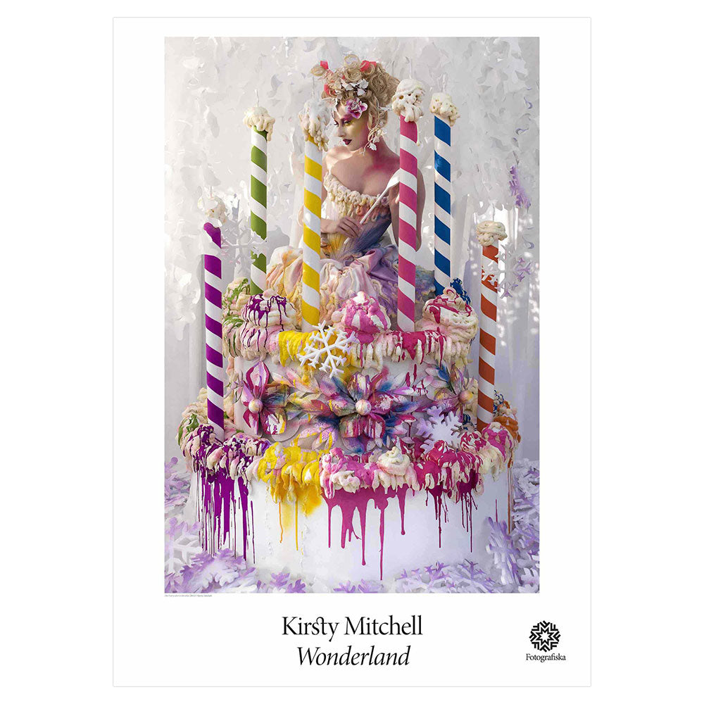 Colorful portrait of woman atop a cafe with giant candles. Exhibition title below: Kirsty Mitchell | Wonderland