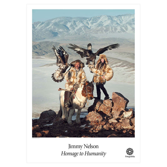 Group of people in rocky area with raptors. Exhibition title below: Jimmy Nelson | Homage to Humanity