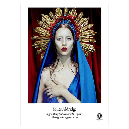 Pale woman with lipstick dressed in blue, make eye contact with viewer. Exhibition title below: Miles Aldridge | Virgin Mary, Supermarkets, Popcorn, Photographs 1999 to 2020.