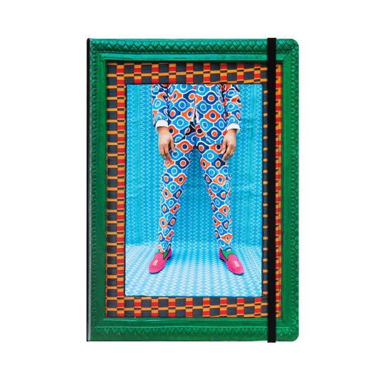 Front of a notebook featuring the colorful Hassan Hajjaj piece Joe Legs, showing legs of vibrantly dressed  male model.