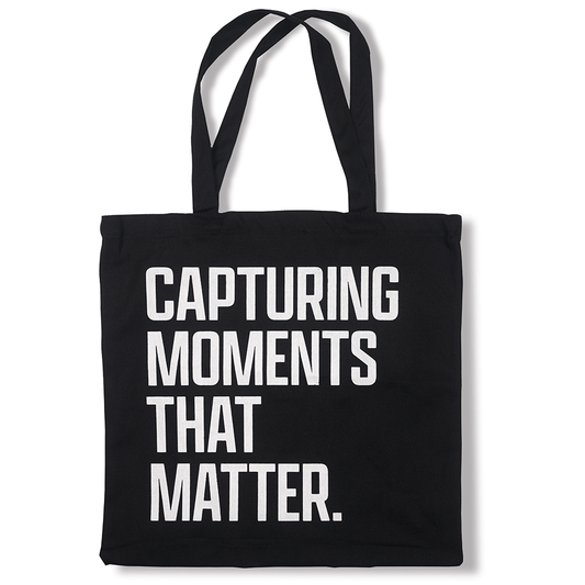 Black tote bag with "Capturing moments that matter" written in the front in white