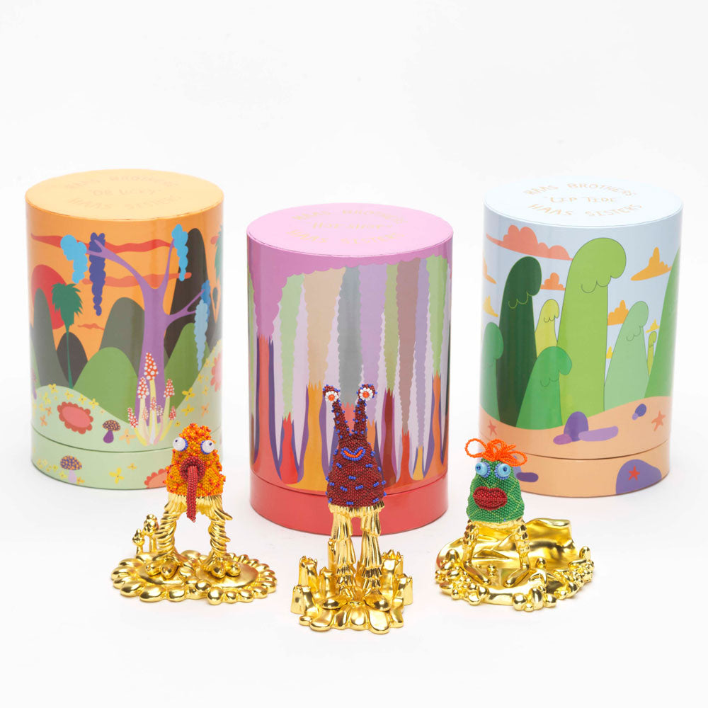 Trio of quirky gold-based statues and packaging.