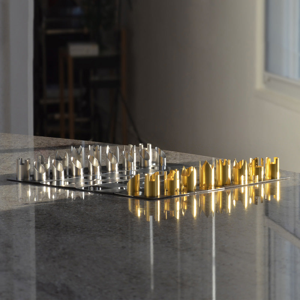 Gold and silver chess pieces on chessboard on countertop
