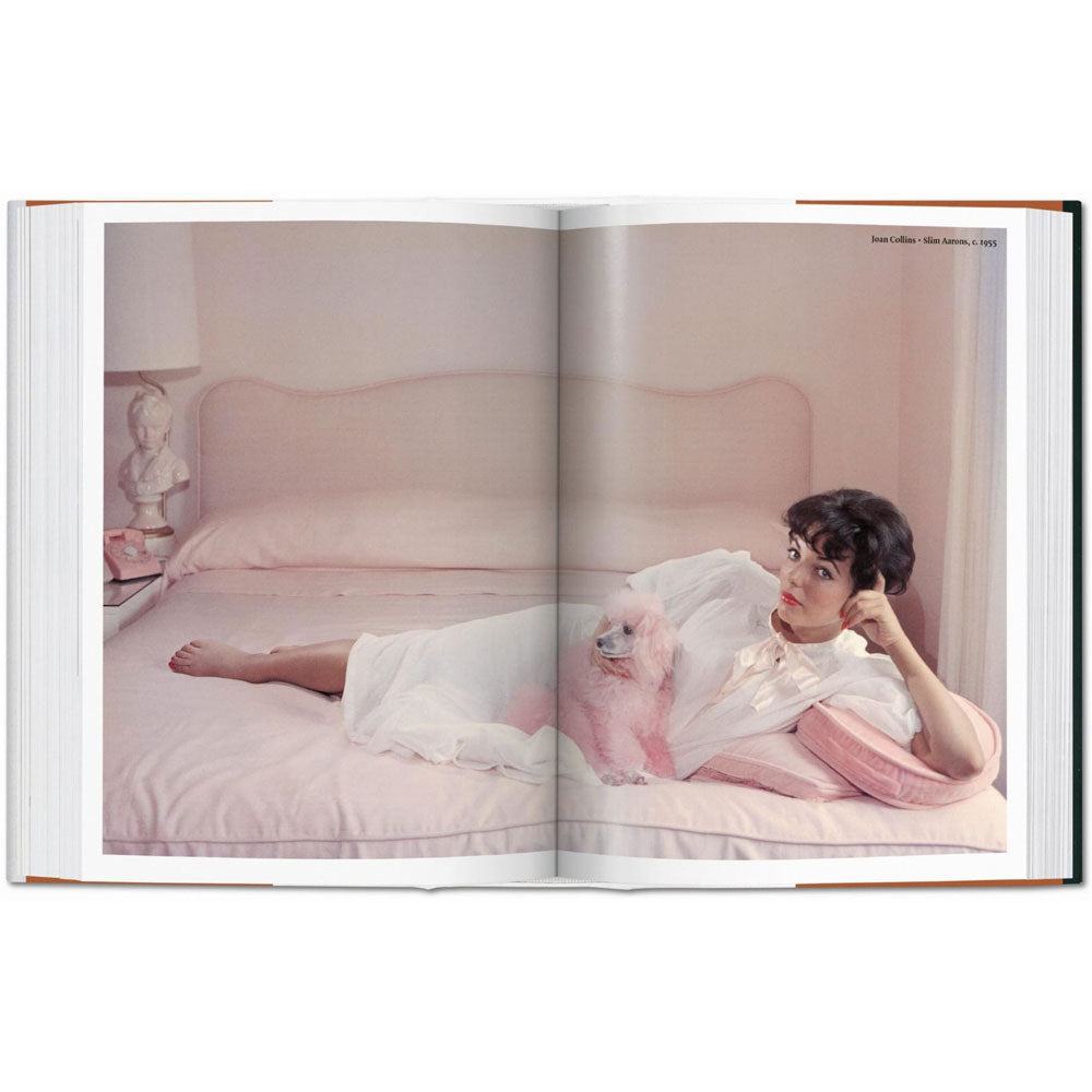 Spread shoot of Dog in Photography book, showing a full-width color photo of Joan Collins lying on a bed with a pink poodle.