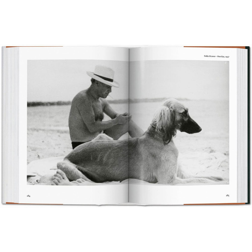 Spread shoot of Dog in Photography book, showing a full-width black and white photo of Pablo Picasso with a dog