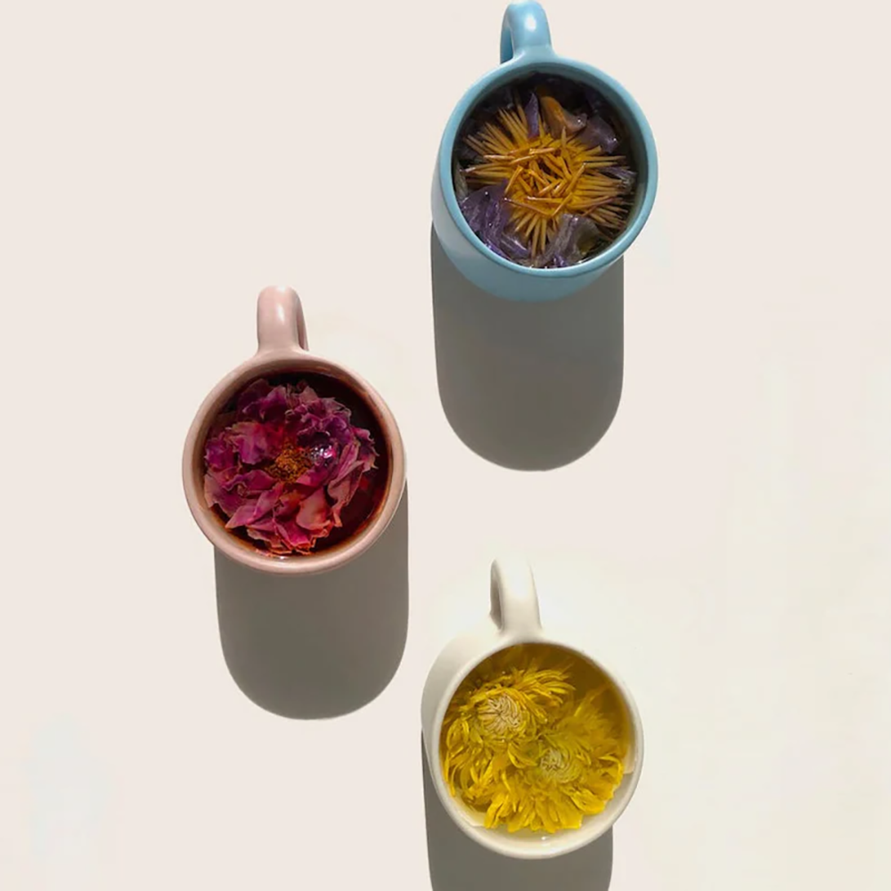Three mugs, each with its own whole flower tea