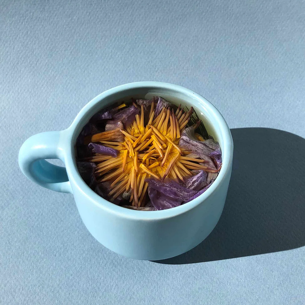 Blue mug, holding whole flower tea