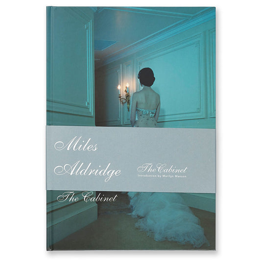 Front cover of Miles Aldridge: The Cabinet catalogue, showing woman in blue-lit bedroom.