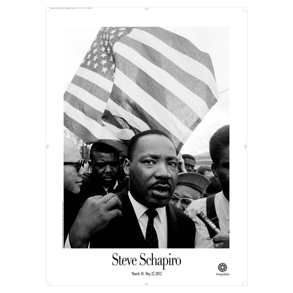 Black and white image of Martin Luther King in front of people with American flag in background. Artist name below: Steve Schapiro