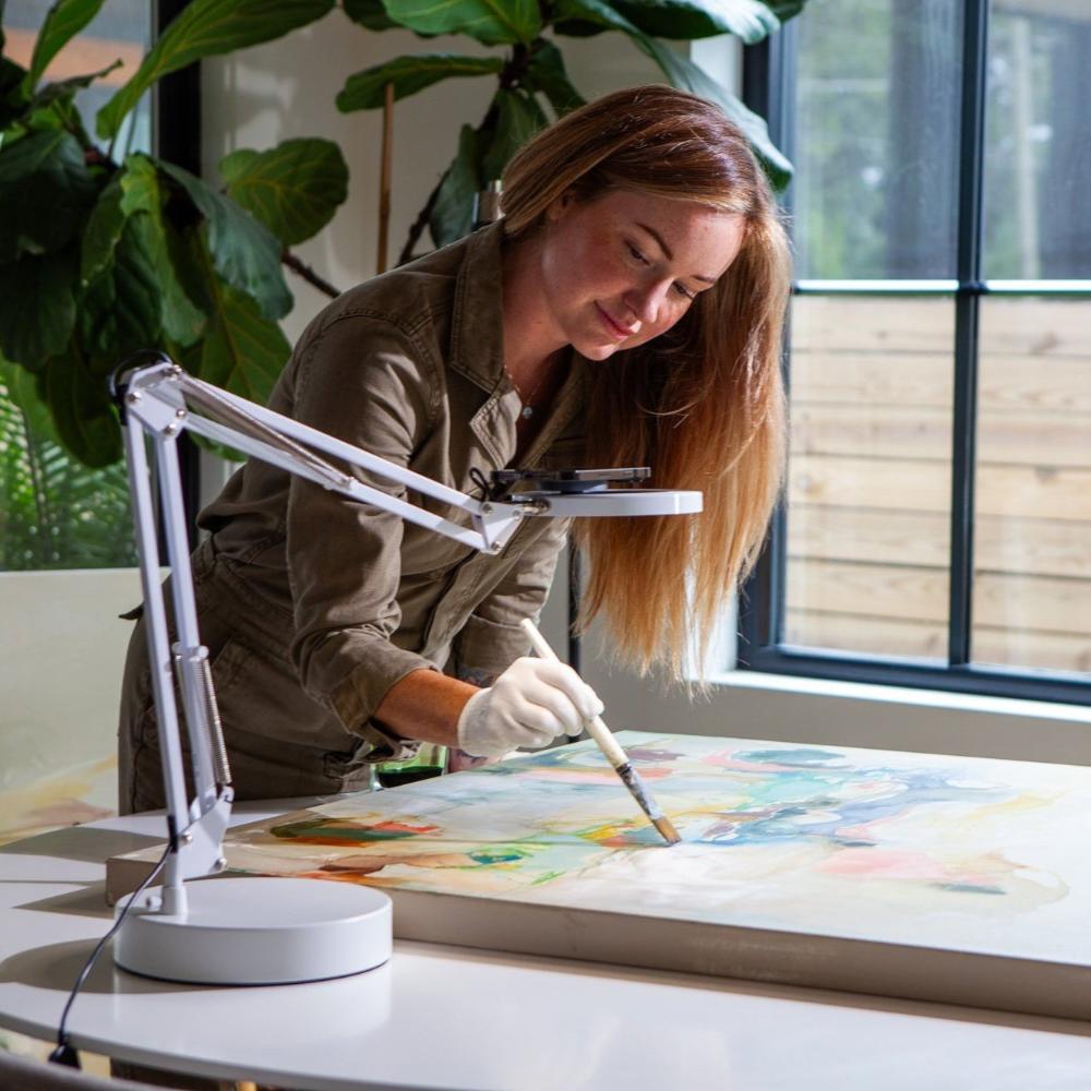 Woman recording herself painting with her smartphone, mounted in the Canvas lamp.