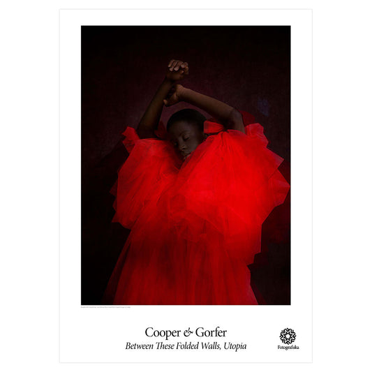 Woman in vivid red dress against black background. Exhibition title below: Cooper & Gorfer | Between These Folded Walls, Utopia