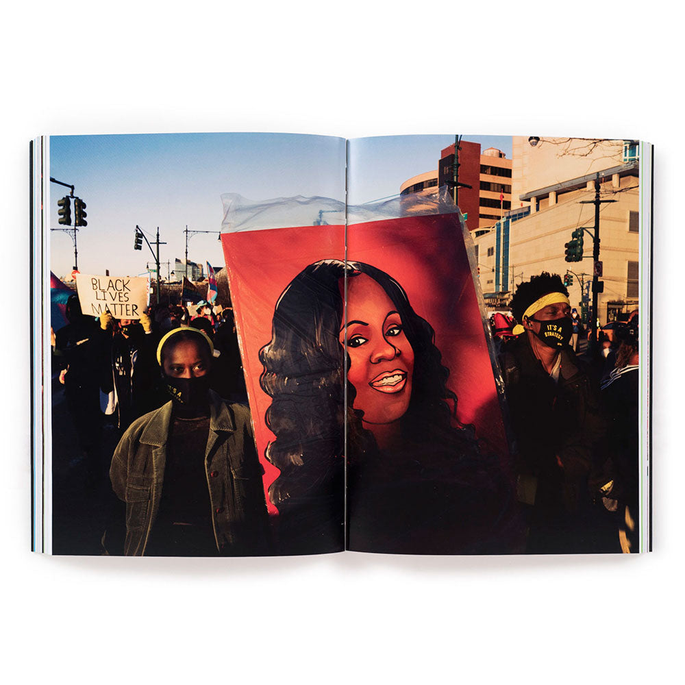 Spread shot of Revolution Is Love: A Year of Black Trans Liberation, showing a full-width photo of protest