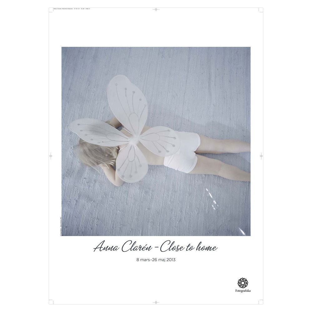 Child laying down with wings.  Exhibition title below: Anna Claire | Close to home