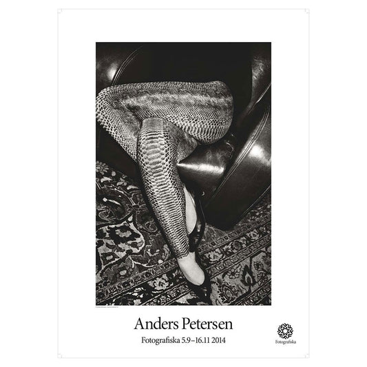 Black & white closeup of legs of seated female, wearing snake leather pants. Artist name below: Anders Petersen