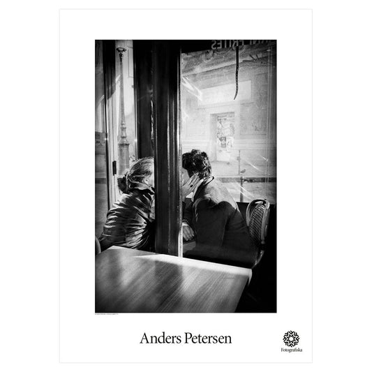 Two people seated with pole in foreground.  Exhibition title below: Anders Petersen