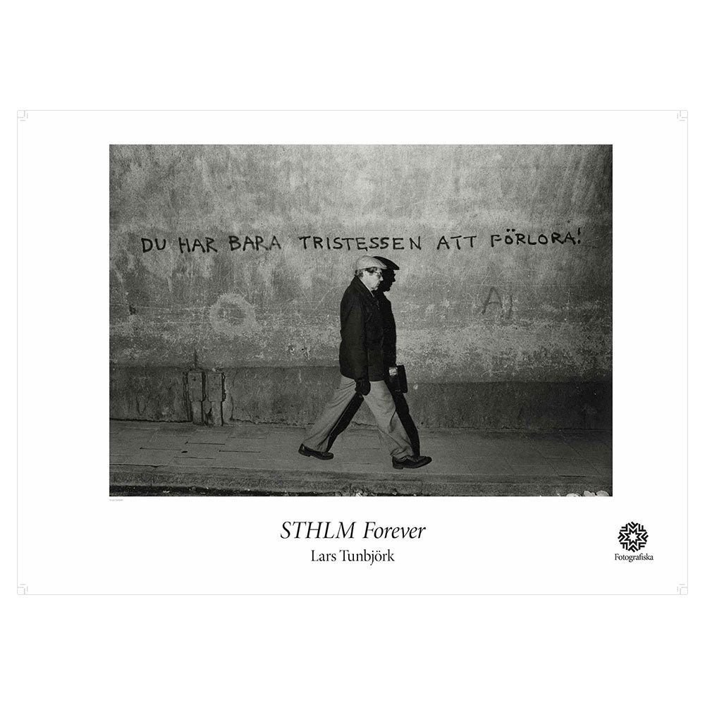 Black and white landscape of person walking alone on street with writing on the walls. Exhibition title below: STHLM Forever | Lars Tunbjork