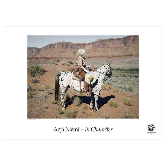 Color photo of blonde woman on harlequin horse in a secluded rocky area. Exhibition title below: Anja Niemi | In Character
