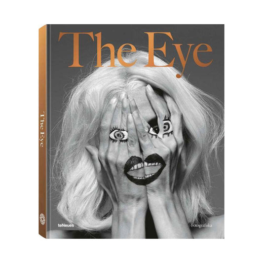 Book cover of The Eye, person covering their face with drawing of a face on their hands.
