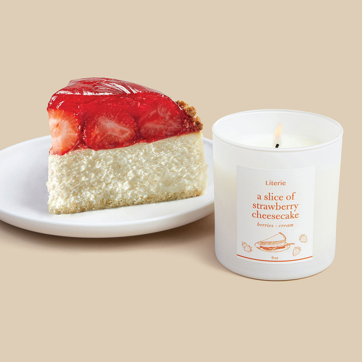 Literie's "A Slice of Strawberry Cheesecake" candle, shown lit next to a slide of strawberry cheesecake.