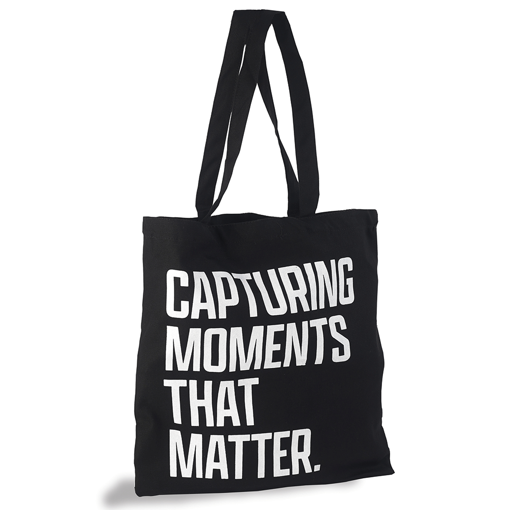 Black tote bag with "Capturing moments that matter" written in white