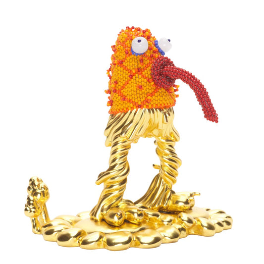 Quirky orange and gold statue of a monster with bugging eyes and tongue sticking out