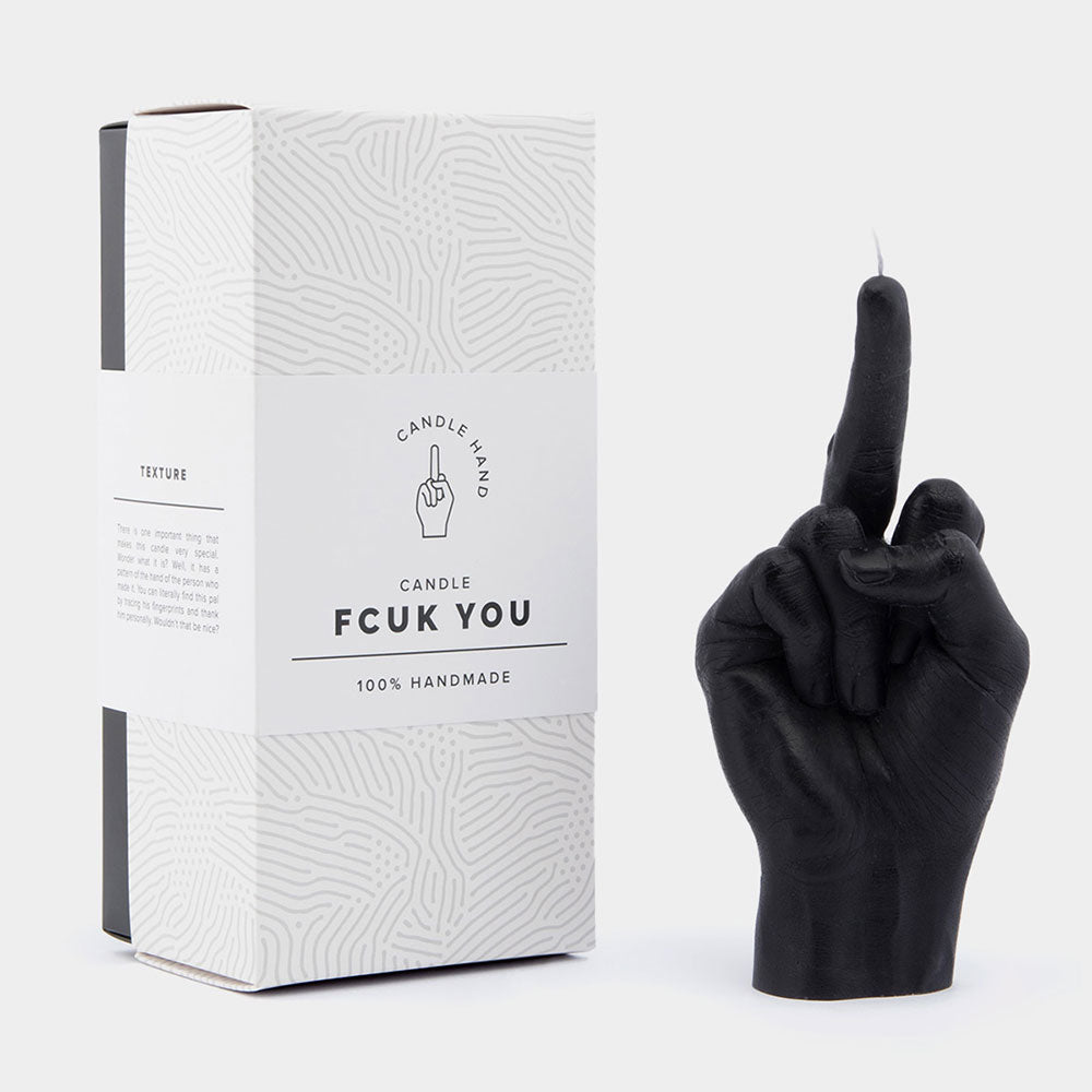 Black middle finger candle beside packaging that says "F*ck you"